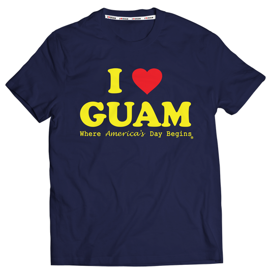 Navy blue unisex t-shirt with ‘I ❤️ GUAM’ in bold yellow letters and a red heart, accompanied by the slogan ‘Where America’s Day Begins’ in yellow text. The design celebrates Guam’s identity and unique time zone.